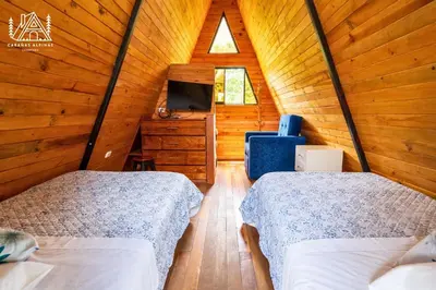 a bedroom with two beds in a wooden cabin at Cabañas Alpinas en Oxapampa in Oxapampa