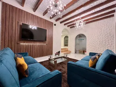 a living room with two blue couches and a tv at Casona Plaza Hotel Cusco in Cusco