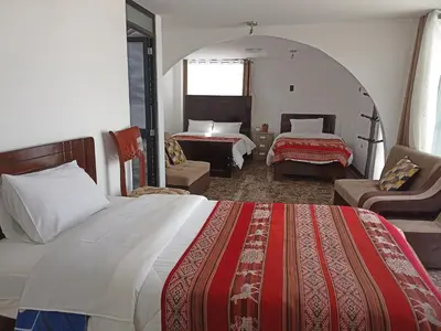 a hotel room with a large bed and a bedroom at Hostal Killaly Inn Cusco in Cusco