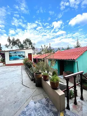 a building with potted plants in a courtyard at Mi Pueblito Lodge in Huancayo