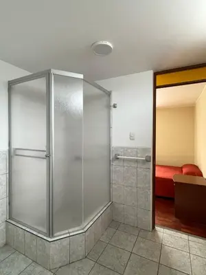 a shower stall in a room with a bed at HOSPEDAJE LAS FLORES ICA in Ica