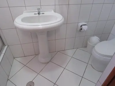 a white bathroom with a sink and a toilet at HOSPEDAJE LAS FLORES ICA in Ica