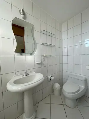 a white bathroom with a sink and a toilet at HOSPEDAJE LAS FLORES ICA in Ica