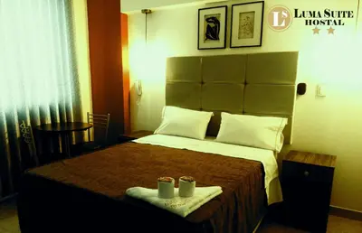 a hotel room with a bed with two cups on it at LUMA SUITE in Lima