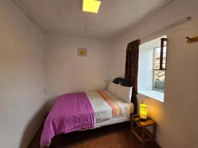 a small bedroom with a bed and a window at Barrio Inka B&B in Cusco