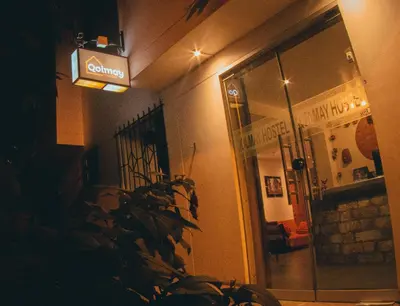 a room with a plant and a sign on the wall at Qolmay Hostel Cusco in Cusco