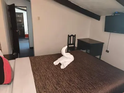 a white towel animal sitting on a bed at SQ Estancia Del Inca in Cusco