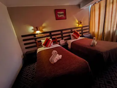 a hotel room with two beds with a stuffed animal on the bed at SQ Estancia Del Inca in Cusco