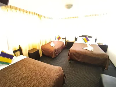 a hotel room with three beds with white swans on them at SQ Estancia Del Inca in Cusco