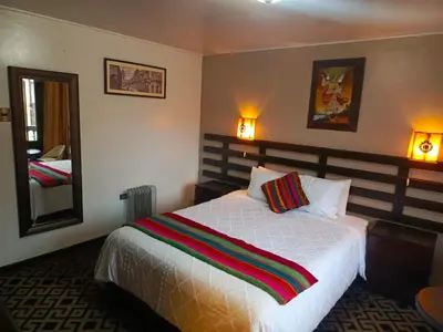 a bedroom with a bed and a mirror and a bed sidx sidx sidx at SQ Estancia Del Inca in Cusco