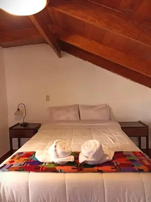 a bedroom with a bed with towels on it at Los Apus Ollantaytambo in Ollantaytambo