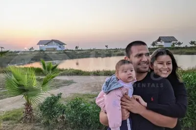 a man and a woman holding a baby at HOP ODAIBA exclusiva laguna y playa en Chincha in Chincha Baja
