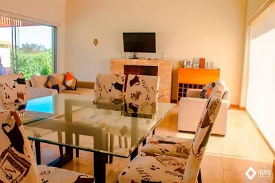 a living room with a glass table and chairs at HOP OHANA exclusiva en campo y playa en Chincha in Chincha Baja