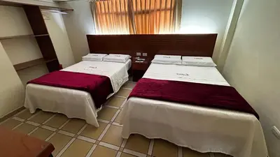 a room with two beds in a room with a window at Hotel Los Arcos de Imperial in San Vicente de Cañete