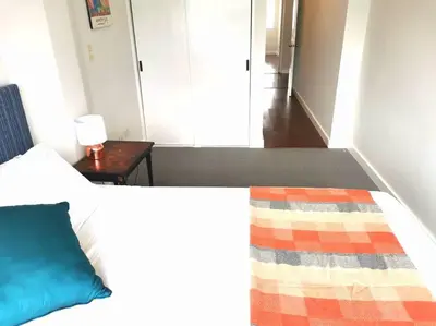 a bedroom with a bed with a blue pillow and a table at Espacio Luxury Apartments Malecón 2 in Lima