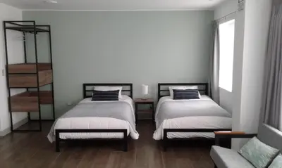 a bedroom with two beds and a window at NEREO rooms in Lima