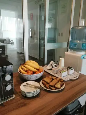 a table with a bowl of bread and a bowl of bananas at NEREO rooms in Lima