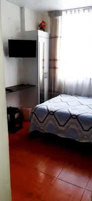 a bedroom with a bed and a large window at Acojedor in Lima