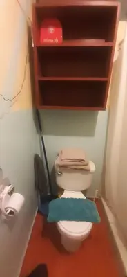 a bathroom with a toilet with a shelf above it at Acojedor in Lima