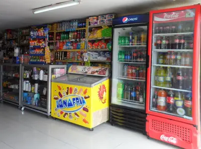 a store aisle with a drink cooler and drinks at Hostal Jovita in Lima