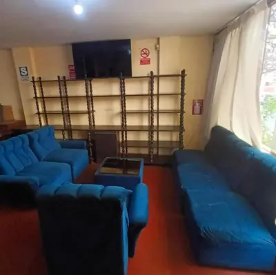 a living room with blue couches and a table at Hostal Jovita in Lima