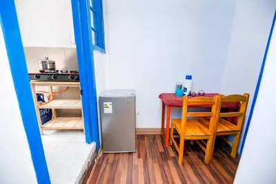 a small kitchen with a table and a small refrigerator at PARDOS HOUSE INN in Cusco
