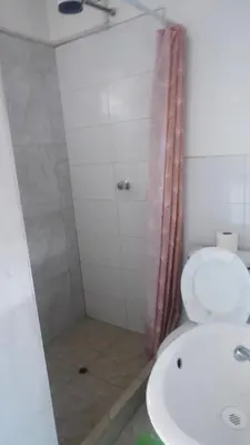 a bathroom with a shower and a toilet and a sink at PARDOS HOUSE INN in Cusco