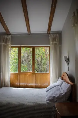 a bedroom with a bed and a window at Eco Lodge Los Perales-Urubamba in Urubamba