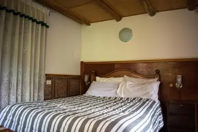 a bed with a wooden headboard in a bedroom at Eco Lodge Los Perales-Urubamba in Urubamba