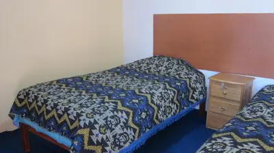 a small bedroom with a bed and a night stand at Garden Inn 488 in Cusco