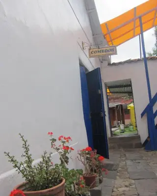 a street sign on the side of a building with flowers at Garden Inn 488 in Cusco