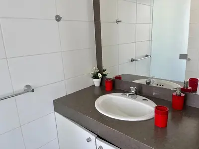 a bathroom with a sink and a mirror at 1 Fila Vista Bahía Paracas - La Velas 501 T1 in Paracas