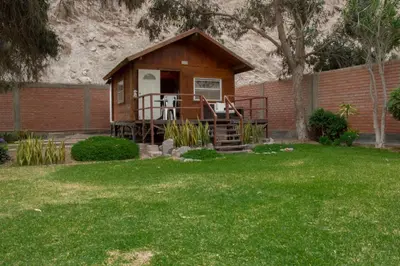 a small cabin with a porch in a yard at VPX Hoteles Cieneguilla in Cieneguilla
