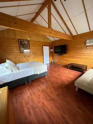 a large room with a bed and a flat screen tv at VPX Hoteles Cieneguilla in Cieneguilla