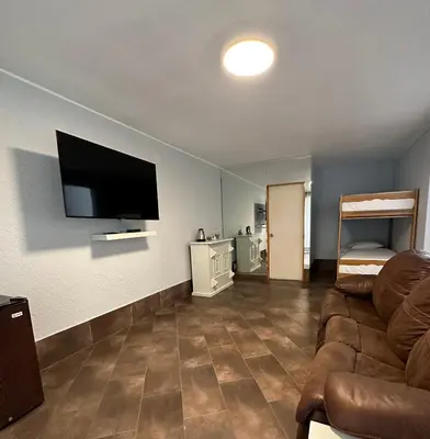 a living room with a couch and a flat screen tv at VPX Hoteles Cieneguilla in Cieneguilla