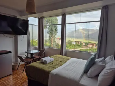a bedroom with a bed and a large window at Casa Yanahuara Valle Sagrado - Urubamba in Urubamba