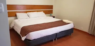a bedroom with a large bed with a wooden headboard at Tilcafé B&B Mollepata in Mollepata