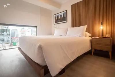 a large white bed in a room with a window at Alta by Wynwood House in Lima