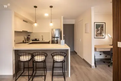 a kitchen with three bar stools at a kitchen counter at Alta by Wynwood House in Lima