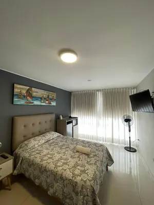a bedroom with a bed and a window at Casa Las Flores Ica in Ica