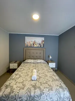 a bedroom with a large bed with a white mattressvisor at Casa Las Flores Ica in Ica