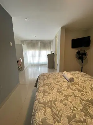 a bedroom with a large bed and a flat screen tv at Casa Las Flores Ica in Ica