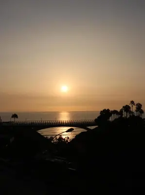 a sunset over the ocean with palm trees at Terrazas Apartments Miraflores in Lima