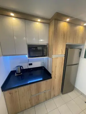 a kitchen with wooden cabinets and a black counter top at Departamento completo Surquillo/Miraflores in Lima