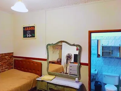 a bedroom with a bed and a mirror on the wall at La Quinta Alcanfores in Lima