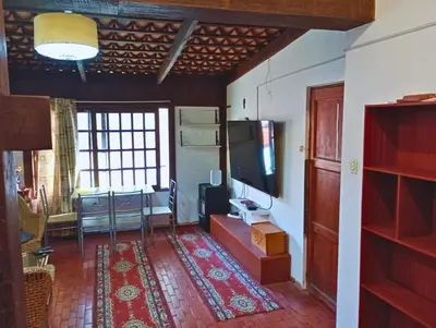 a living room with a tv and a table and a room at La Quinta Alcanfores in Lima