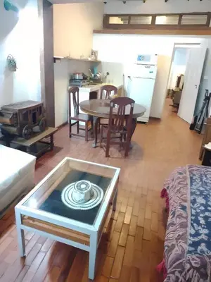 a living room with a table and a kitchen at La Quinta Alcanfores in Lima