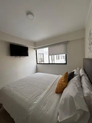 a large white bed in a bedroom with a window at Apartamento acogedor en Barranco - cerca a Miraflores in Lima