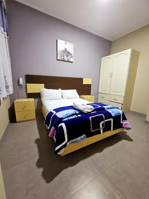 a bedroom with a bed with a blue blanket on it at Hotel La Suite de Angelique Huacho in Huacho