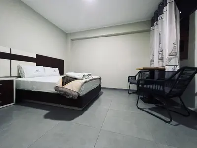 a bedroom with a bed and a desk and a chair at Hotel La Suite de Angelique Huacho in Huacho